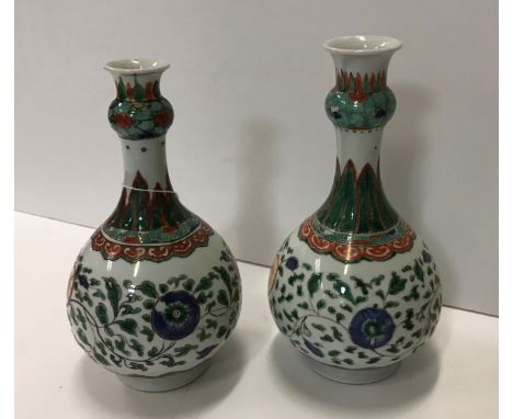 A matched pair of Chinese Kangxi famille verte onion-shaped vases with all-over scrolling floral and foliate decoration, the 