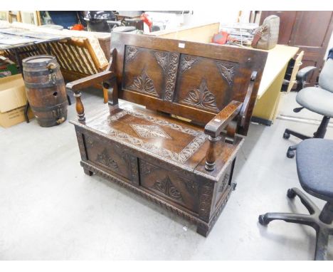 A CARVED OAK MONKS BENCH 