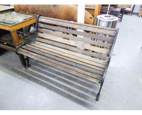 A GARDEN BENCH WITH DECORTIVE METAL SIDE WITH SLATS 