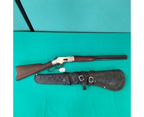 A replica Winchester rifle, wood and metal construction with a tooled leather scabbard