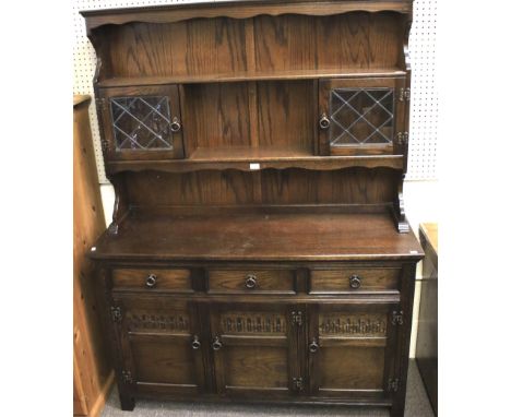 A 20th century dark stained dresser. With open shelf and two glazed cupboards over a three drawer and three door base. 137cm 