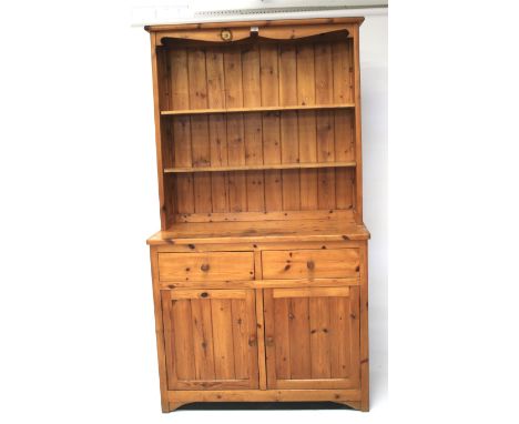 A contemporary pine kitchen dresser. The upper section with two adjustable shelves, the lower section with two drawers positi