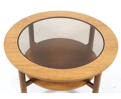 A mid-century glass topped circular coffee table. On four cylindrical legs, joined by a lower shelf, 84cm diam. x H45cm 