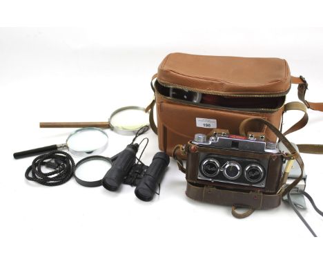 An assortment of scientific and photographic instruments. Including magnifying glasses, a compass, Owla Stereo camera no 3437