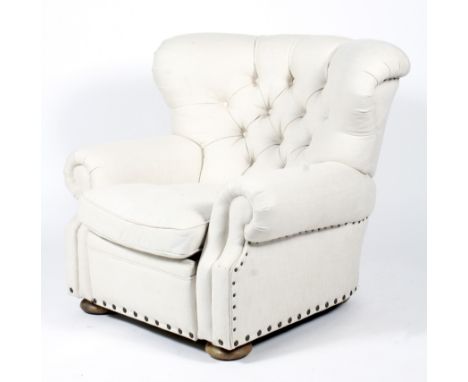 A contemporary reclining upholstered button back armchair. Upholstered in studded cream calico, with drop in cushion and recl