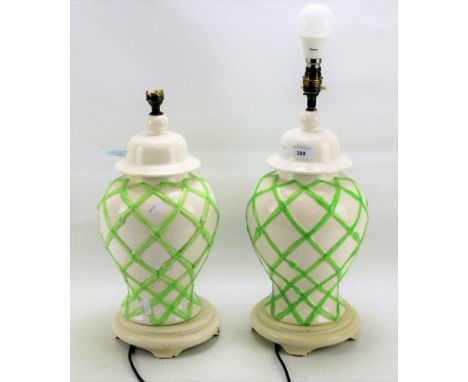 A pair of modern glazed ceramic table lamps. With green bamboo moulded decoration, on a white ground, 39cm high excluding fit