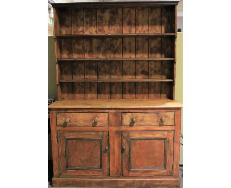 A 20th century pine kitchen dresser. The upper section with three shelves of ascending size, the lower section with two short