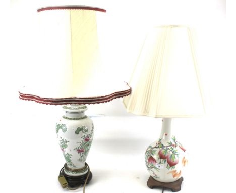 Two oriental ceramic table lamps. Both decorated with flowers on a white glaze, white shades, tallest H45cm (excluding shade)