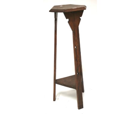 An Arts and Crafts jardinere stand. With hexagonal top on tripod pierced support with lower shelf. H91cm