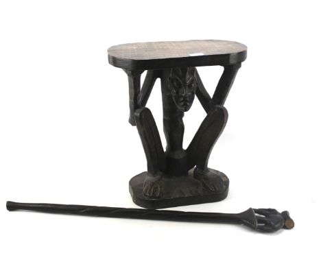 Two carved tribal wooden wares. To include a grotesque stool and a walking stick, the stool measuring 48cm high.PROCEEDS TO B