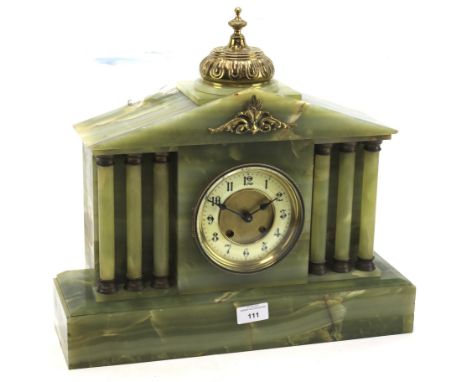 A late 19th century French onyx mantle clock. The circular dial with Arabic numerals denoting hours, flanked on either side b