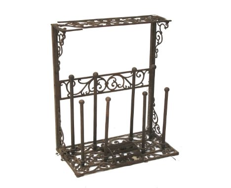 A late 19th century cast iron boot stand. The top shelf raised over eight metal boot mounts, with shoe scraper, L65cm x D34cm
