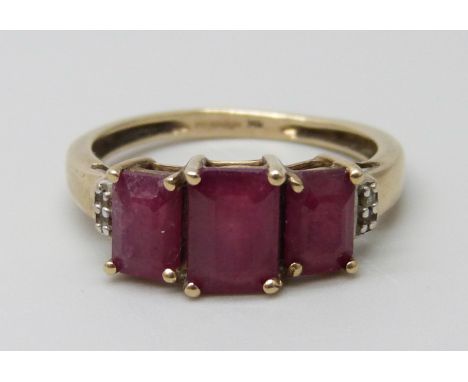 A 9ct gold three stone ruby ring set with diamonds, 2.4g, O