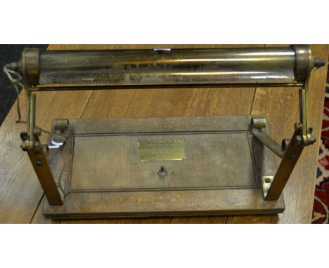 An early 20th century oak and brass adjustable library / desk lamp, rolling shutter light cover, brass commemorative plaque 