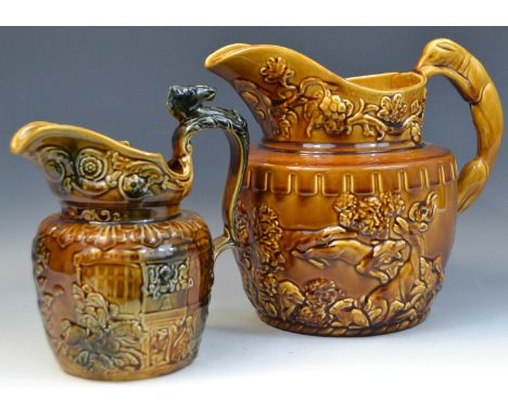 A substantial Woods treacle glazed ale jug decorated in relief with floral sprigs, bear and stag hunting scenes; another simi
