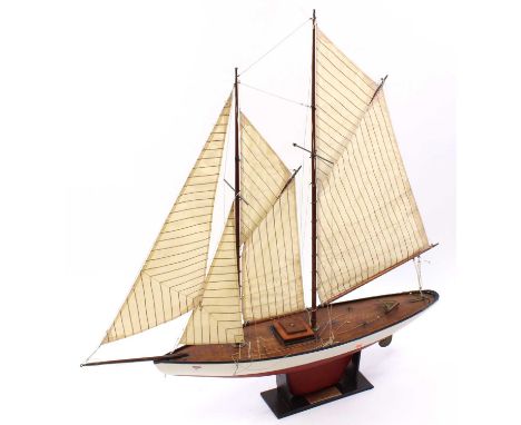 A wooden scratch built scale model of an Edwardian schooner rigged pond yacht, comprising of red and white wooden hull with w