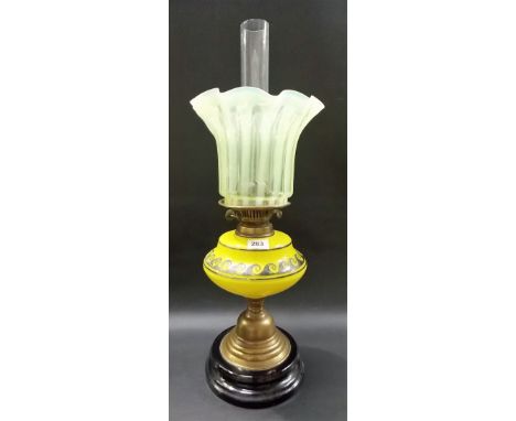 19th Century brass and glass oil lamp, the frilled yellow opaline shade over the yellow glass reservoir and on black pottery 