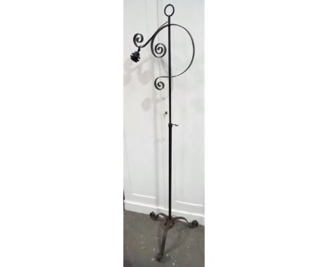 Arts & Crafts style wrought iron telescopic standard lamp on tripod base.