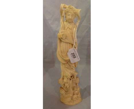 A Meiji period Okimono, a carved ivory figure of a lady playing a stringed instrument, having a stylized dragon at her feet, 