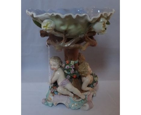 A 19th Continental porcelain centrepiece, having a lilac glazed bowl over trunk effect column, surrounded by three cherubs on