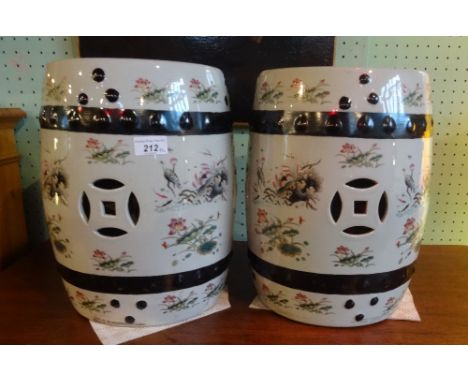A pair of early 20th century Chinese ceramic garden seats, each decorated with hand painted flora and fauna, each 35cm tall.