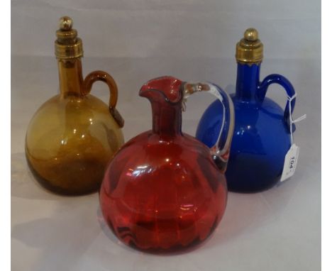 Three coloured glass decanters, two with gilt stoppers. Condition Report: Good condition, with age related wear to the foot o