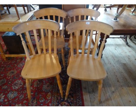 A set of four stick back dining chairs.