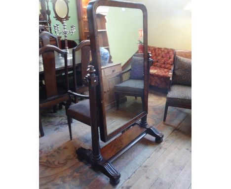 A mahogany cheval mirror, with slightly arched plate, the frame with turned column supports, purchased from Christie's sale a
