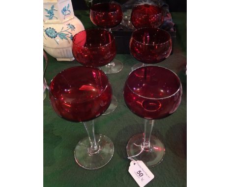 A set of six Val St Lambert wine glasses, having ruby coloured bowls on clear glass faceted stems over circular foot, etched 