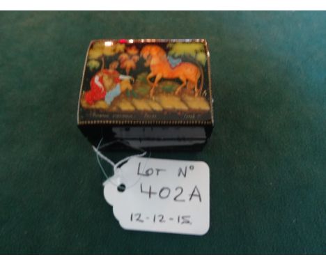 A 20th century Russian papier mache and enamel box, the cover bearing the image of a soldier resting beside his horse, signed