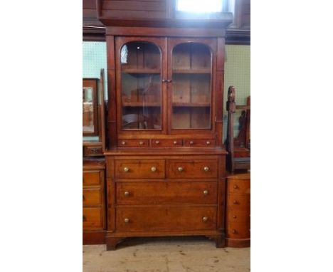 A Victorian oak dresser, having twin glazed doors over two short and two long drawers on bracket feet, 111cm wide.