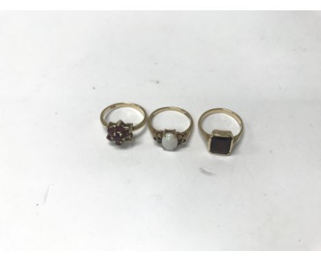 Three gold rings, an opal ring, a garnet ring and one set with rubies. Total approx weight 6.3g, sizes between K and M.