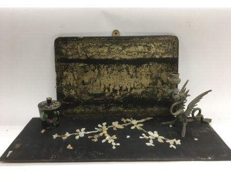 Four Oriental items comprising a lacquered panel depicting figures in a court scene, a cloisonne pot and cover with a black g