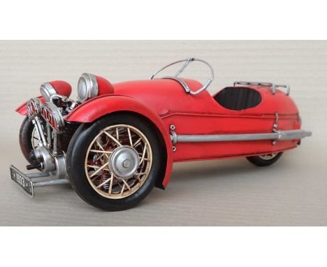 A group of nine scale model three wheeled red steel cars, 12x18x34cm. (9)