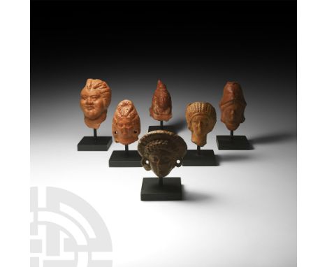 1st century BC-2nd century AD. A group of votive terracotta figure heads comprising: a helmetted head of Minerva (Greek Athen