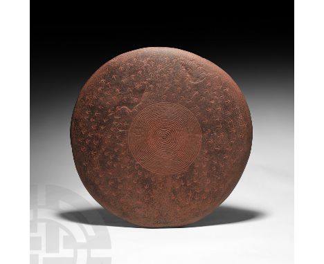 Mid 20th century AD or earlier. A lentoid-section, discoid sandstone totem comprising two engraved faces: one face with a tig