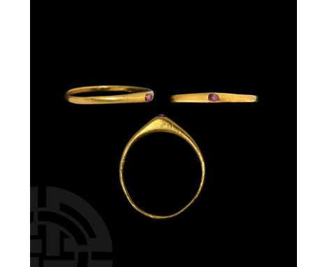 13th-14th century AD. A gold stirrup ring with D-section hoop and conical bezel set with a cut and polished amethyst cabochon