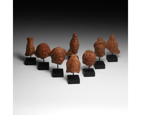 2nd century AD. A group of votive terracotta figures comprising: the head of god Serapis, depicted bearded as Zeus, with a bu