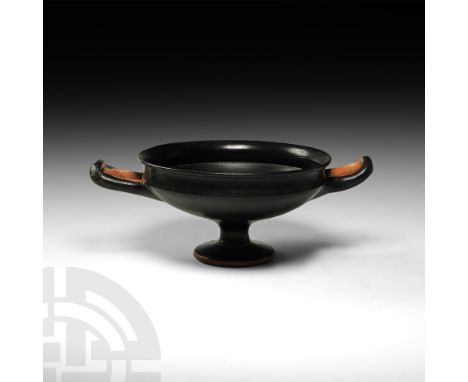 4th century BC. A ceramic blackware stemmed kylix with carinated bowl and two arched strap handles.  210 grams, 14cm diameter