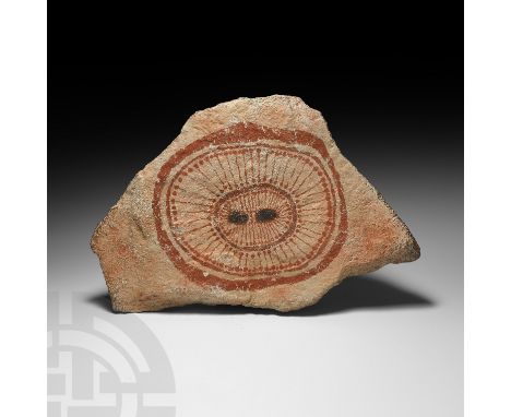 Mid 20th century AD or earlier. A Wandjina head painted in red ochre on a 'white' background, on an irregular portable stone 