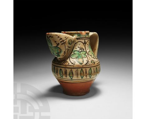 14th-15th century AD. A glazed terracotta jug or pitcher with carinated body, broad, U-section spout and broad strap handle, 