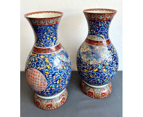 A pair of large Japanese porcelain baluster shaped vases - first half 20th century, painted with a phoenix, its tail issuing 