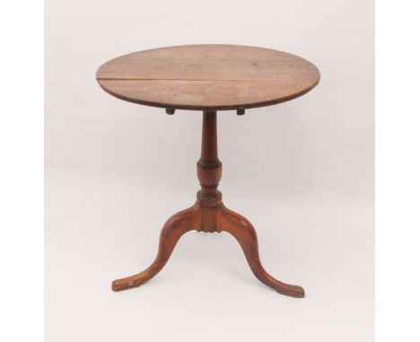 A George III oak tilt-top tripod table - the circular top on a turned gun-barrel column to three swept supports with pad feet