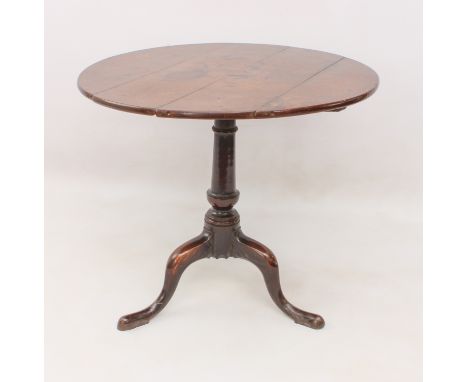 A George III oak tilt-top tripod table - the circular top on a turned gun-barrel column to three swept supports with pointed 