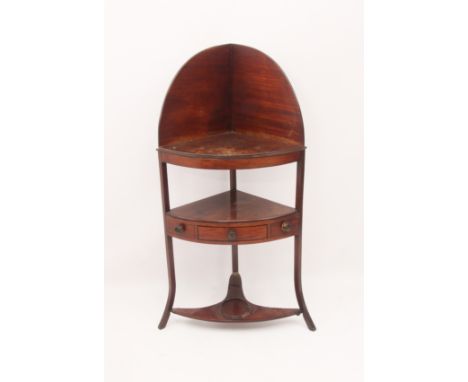 A Regency mahogany corner washstand - with a peaked back over a solid top shelf and ebony-strung undertier with a central dra
