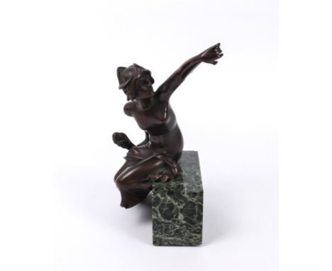An Art Nouveau bronze of a seated nude maiden - holding a flaming torch in one hand, the other held aloft, seated upon a verd