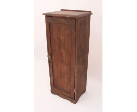 A narrow stained pine cupboard - early 20th century, the panelled door enclosing a two-shelf interior, on a plinth base. (LWH