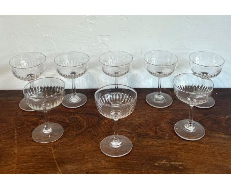 A set of eight Edwardian cut glass champagne bowls / saucers - the cupped bowls with a band of slice cut decoration, on plain