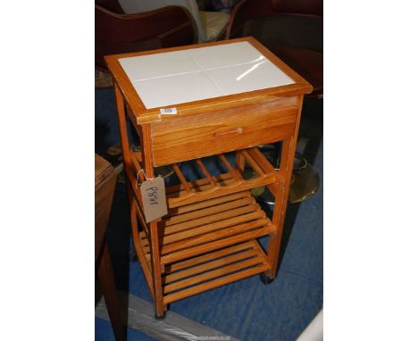 A tile top small kitchen unit with top drawer and lower shelf on castors, 18 1/2" x 14 1/2" x 32".