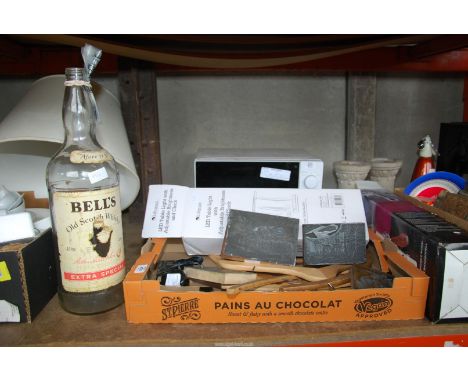 A box of print blocks, table light, wooden coat hangers, large Bells Whisky bottle, etc.